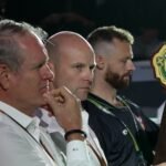 Desert Vipers officials at their table during the ILT20 Season 5 auction in Dubai, with the team's bidding paddle