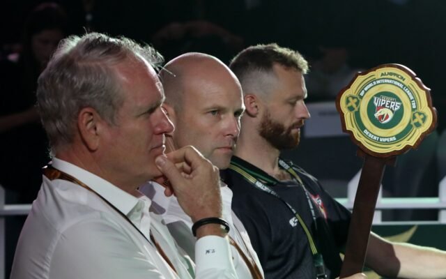 Desert Vipers officials at their table during the ILT20 Season 5 auction in Dubai, with the team's bidding paddle